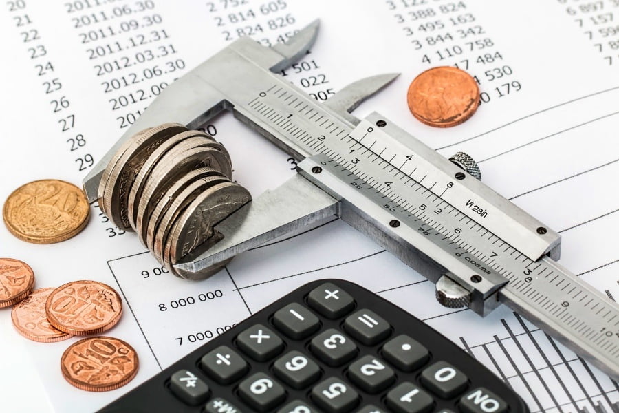pirnting supplies. reciept, calculator and wrench pinching coins