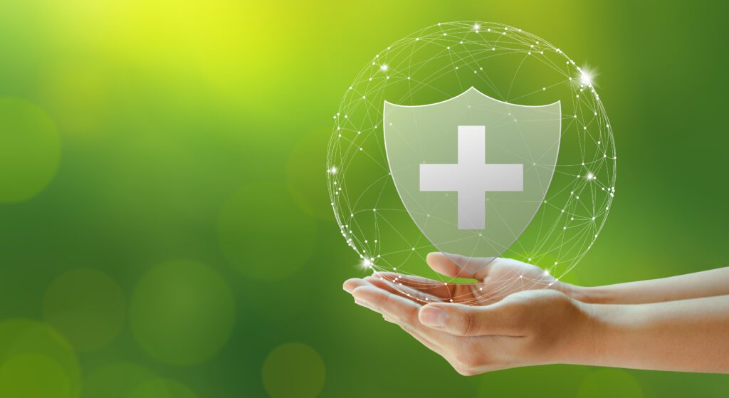 Hand offer medical shield on green background. Family life insurance, Medical care insurance, and Business healthy concepts.